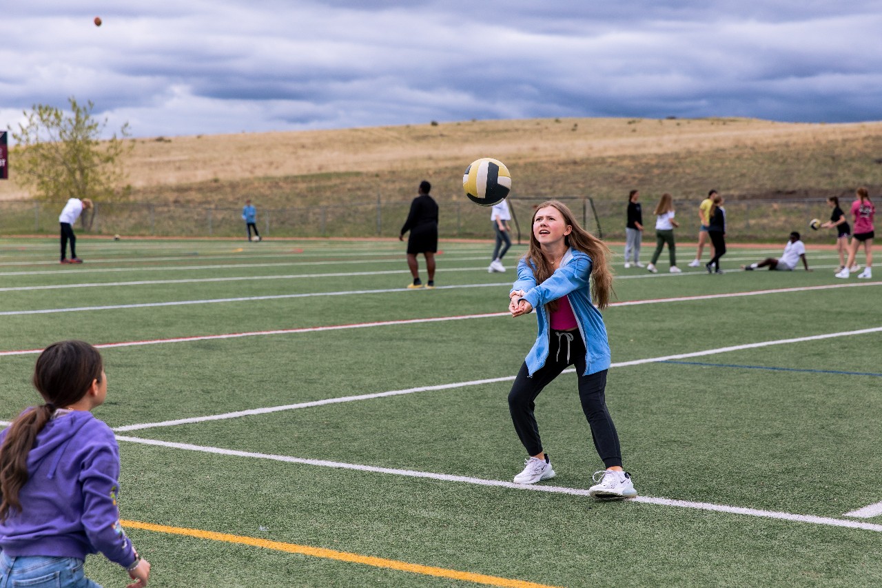 An Eagleview athlete practices volleyball on the field.